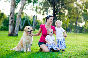 Mother and her two sons in the park with a golden retriever