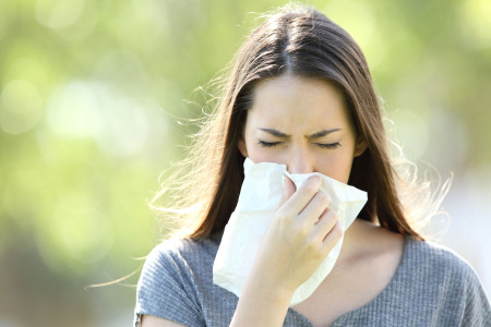 Girl sneezing and blowing in a wipe