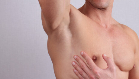 Close up of muscular male torso, chest and armpit hair removal. Male Waxing