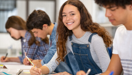 Satisfied,Young,Woman,Looking,At,Camera.,Team,Of,Multiethnic,Students